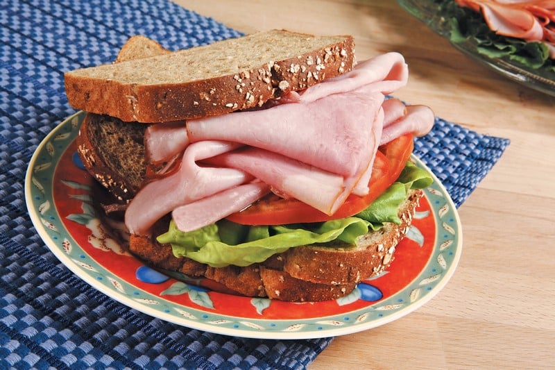 Ham Sandwich on Decorative Plate and Blue Placemat Food Picture
