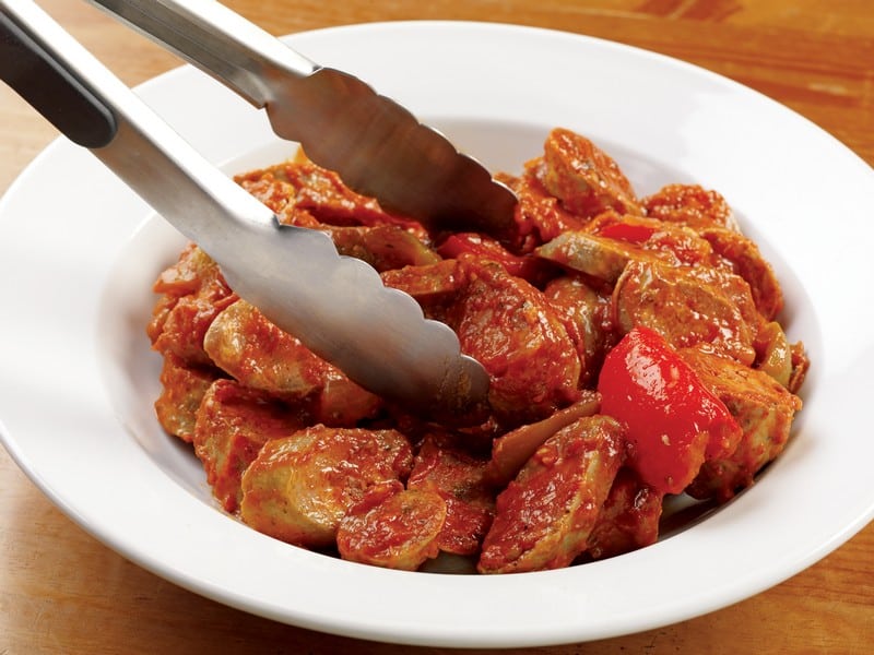 Sausage and Peppers in Sauce in White Dish and Tongs Food Picture